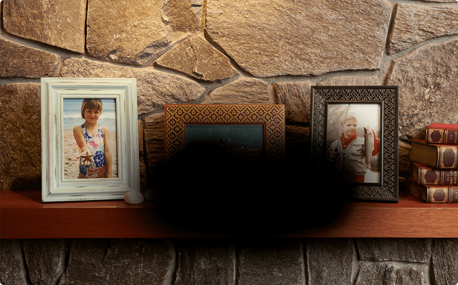framed pictures on a mantel with black spot blocking view